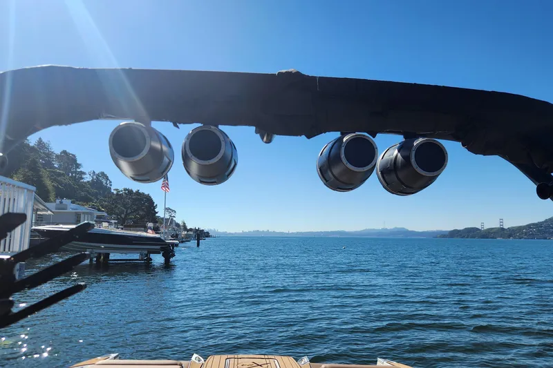 Slide: The Image of 2024 MasterCraft X24 boat speakers overlooking scenic waterfront and distant bridge. - 21