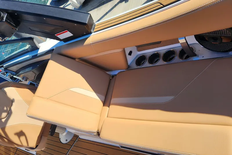 Slide: The Image of 2024 MasterCraft X24 boat interior with tan leather seats and cup holders. - 22