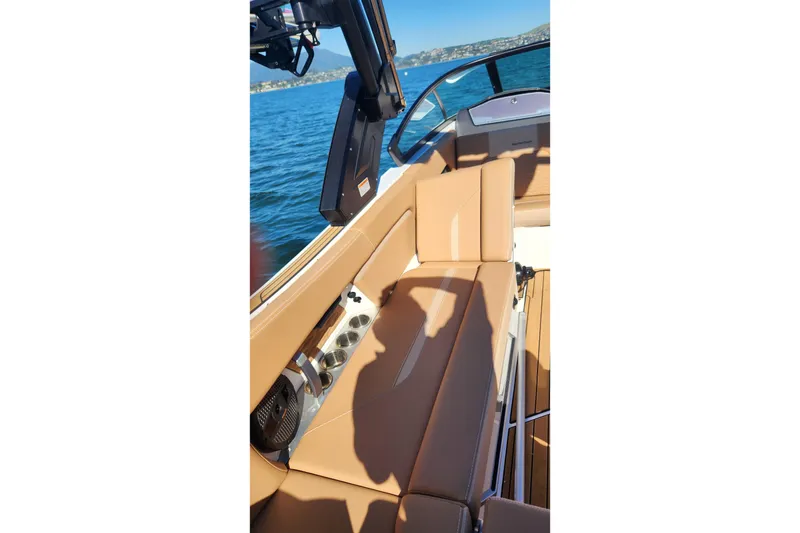 Slide: The Image of 2024 MasterCraft X24 boat interior with tan seating on a sunny day. - 23
