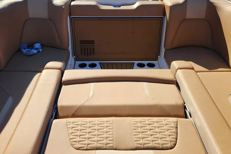 Slide: The Image of 2024 MasterCraft X24 boat interior with tan leather seating and cup holders. - 6