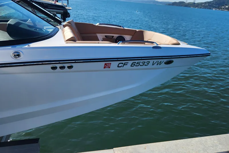 Slide: The Image of 2024 MasterCraft X24 boat docked on a serene lake. - 8