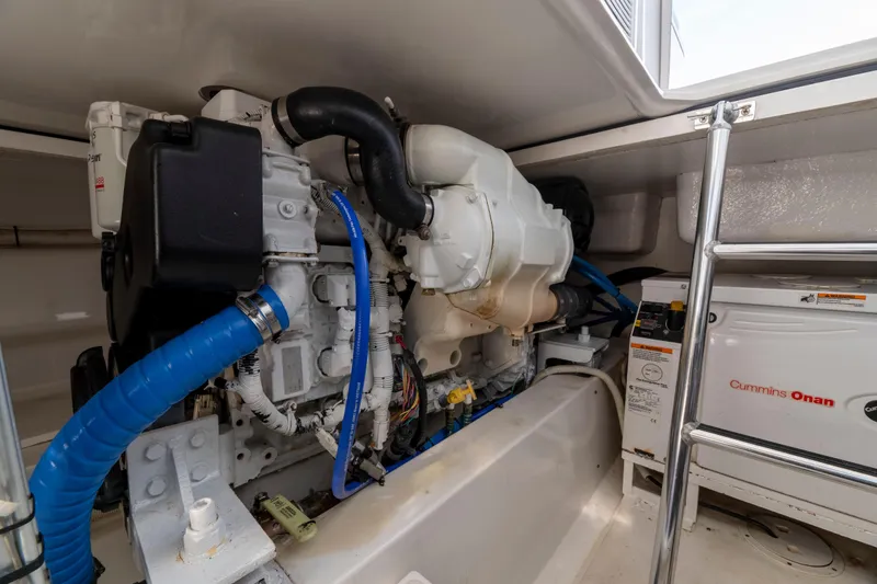 Slide: The Image of Engine room of 2015 Ocean Yachts 37 Express with Cummins Onan generator and blue hoses. - 19