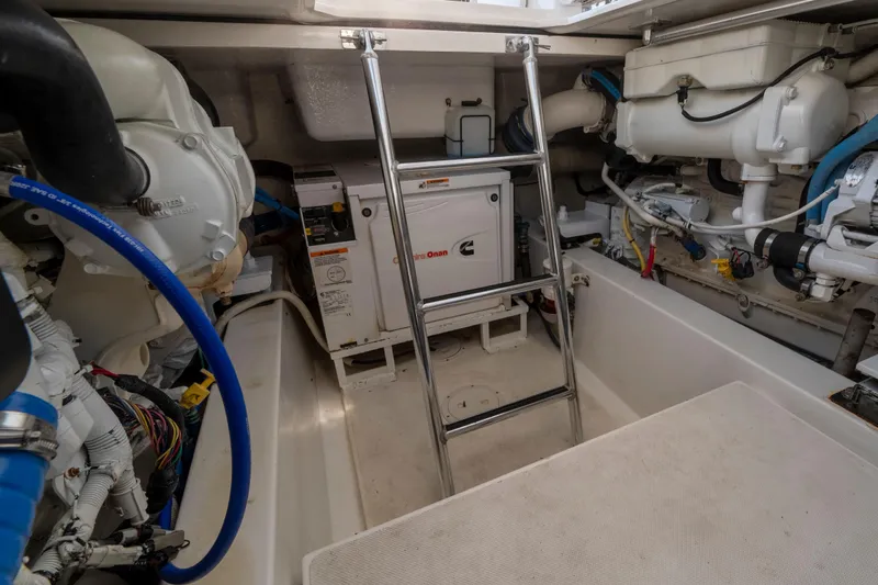 Slide: The Image of Engine room of 2015 Ocean Yachts 37 Express, featuring Cummins generator and ladder access. - 20