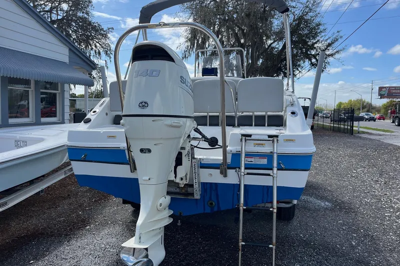 Slide: The Image of 2020 Hurricane Center Console 19 OB boat with Suzuki 140 outboard motor, parked outdoors. - 12