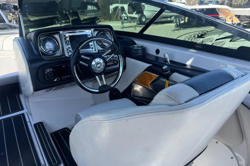 Slide: The Image of Interior of 2011 Nautique Super Air Nautique 230 boat, featuring steering wheel and dashboard controls. - 19