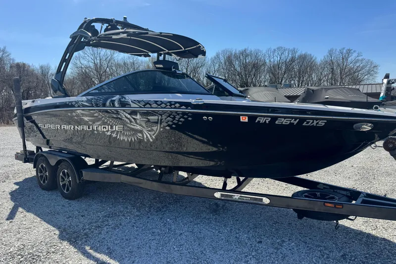 The Image of 2011 Nautique Super Air Nautique 230 boat on trailer, parked outdoors. - 7