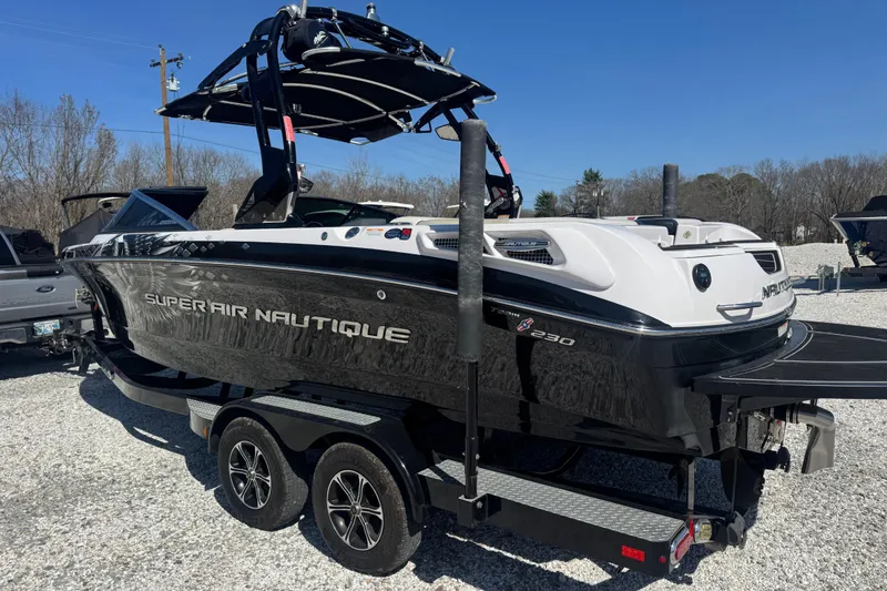 Slide: The Image of 2011 Nautique Super Air Nautique 230 boat on trailer, black and white design. - 9
