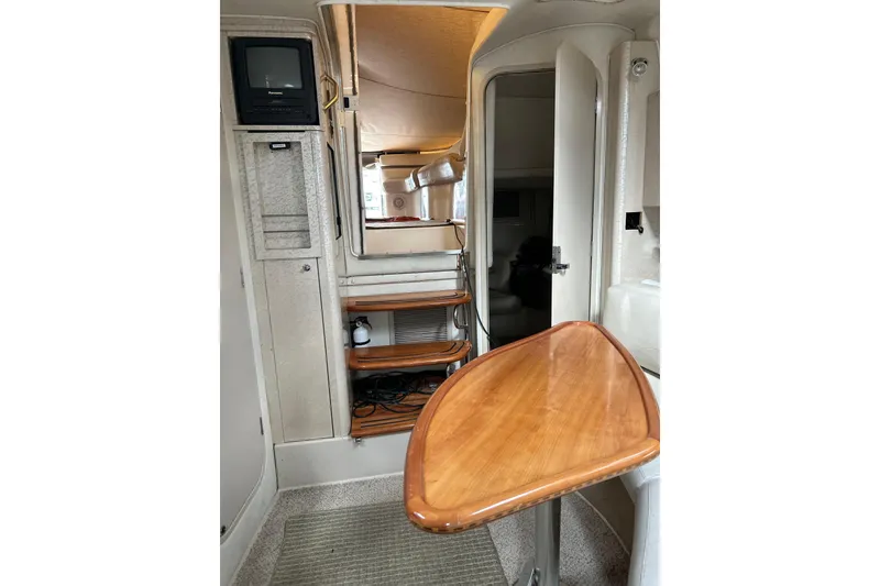 Slide: The Image of Interior of 2001 Doral 330se boat with wooden table and compact TV unit. - 9