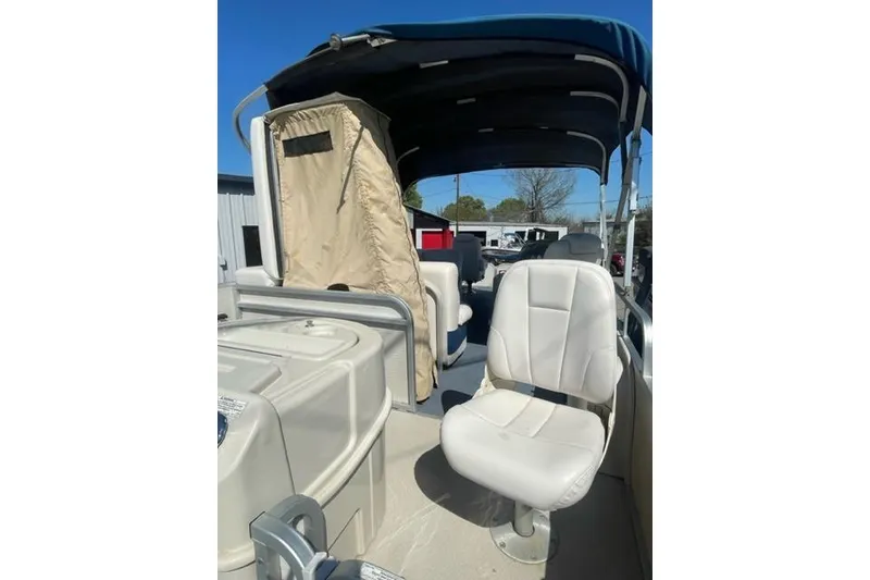 Slide: The Image of 2009 Premier 221 Cast-A-Way boat interior with seating and canopy under clear blue sky. - 6