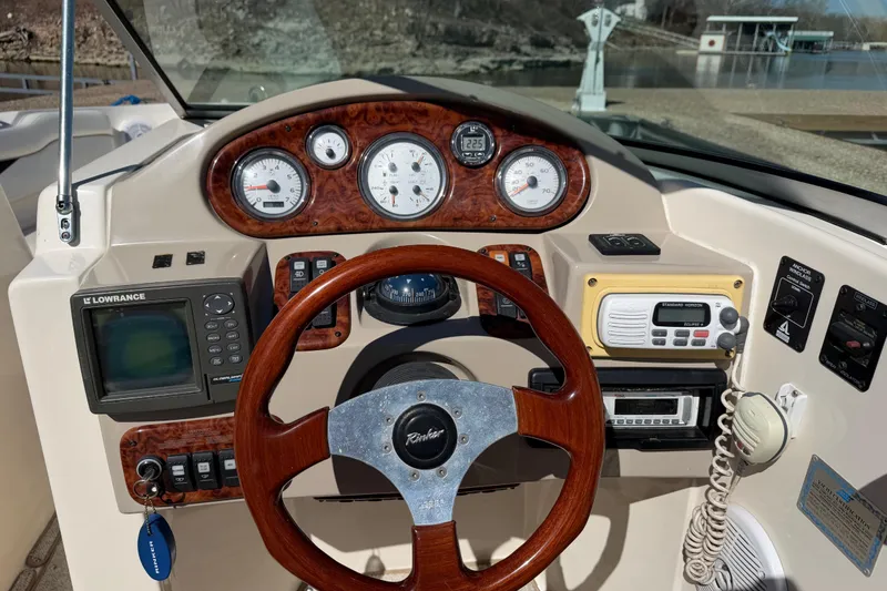 Slide: The Image of 2003 Rinker 282 Captiva Bowrider dashboard with steering wheel and navigation instruments. - 10