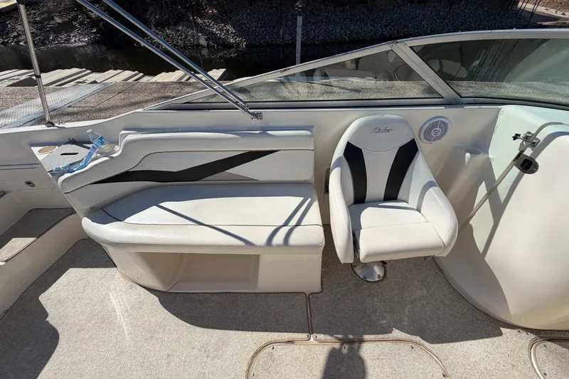 Slide: The Image of 2003 Rinker 282 Captiva Bowrider interior with white seating and steering area. - 17