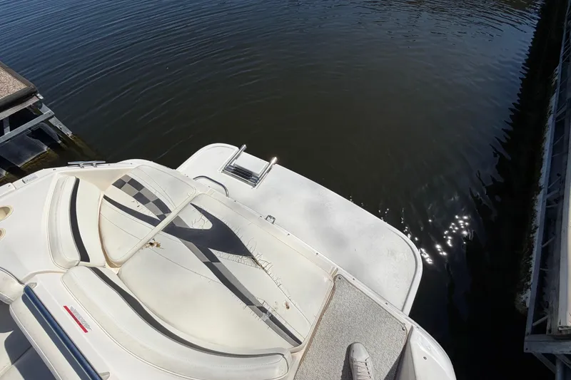 Slide: The Image of 2003 Rinker 282 Captiva Bowrider boat docked by calm water. - 19
