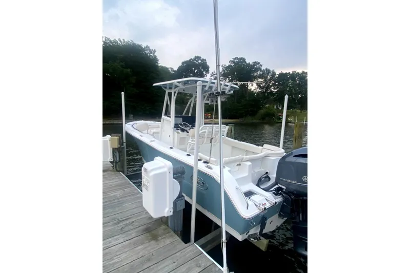 The Image of 2020 Sea Hunt Ultra 225 boat docked, featuring sleek design and powerful outboard motor. - 0