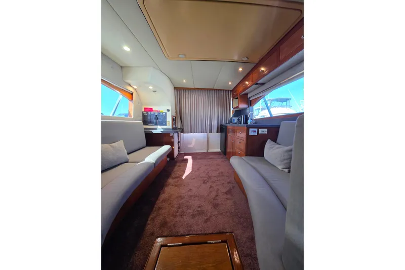 Slide: The Image of Interior of 2002 Luhrs 34 Convertible yacht with plush seating and wooden cabinetry. - 17