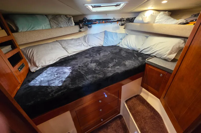 Slide: The Image of Cozy cabin interior of 2002 Luhrs 34 Convertible with plush bedding and wooden cabinetry. - 23