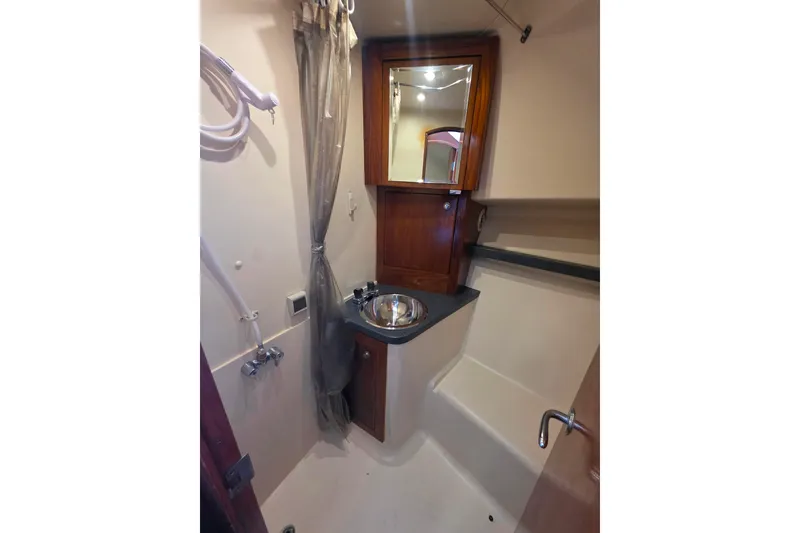 Slide: The Image of 2002 Luhrs 34 Convertible yacht bathroom with sink, mirror, and shower area. - 25