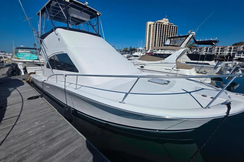 Slide: The Image of 2002 Luhrs 34 Convertible yacht docked at marina under clear blue sky. - 26