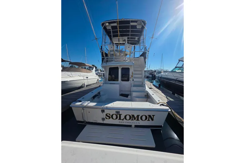 Slide: The Image of 2002 Luhrs 34 Convertible boat docked in San Diego marina under clear blue sky. - 28