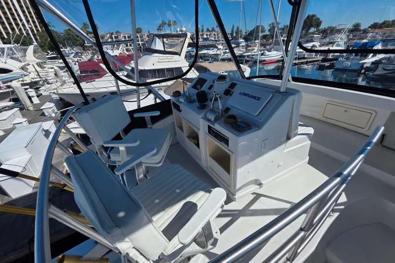 Slide: The Image of 2002 Luhrs 34 Convertible boat cockpit with navigation equipment and marina view. - 5