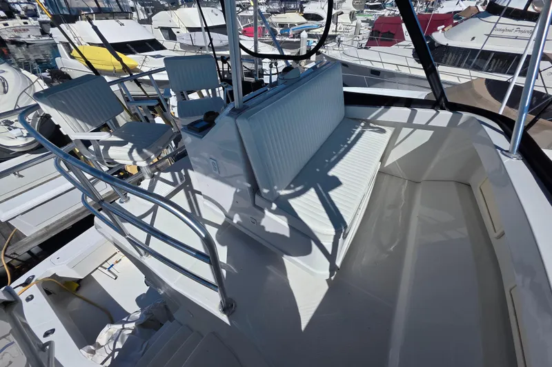 Slide: The Image of 2002 Luhrs 34 Convertible boat deck with seating and railing in marina setting. - 6