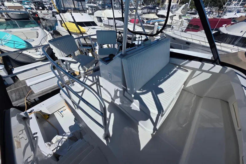 Slide: The Image of 2002 Luhrs 34 Convertible yacht interior with seating and helm, docked at marina. - 7