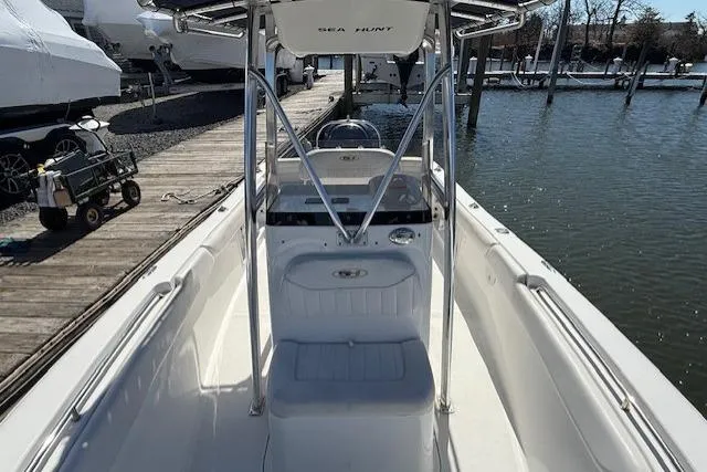 Slide: The Image of 2012 Sea Hunt Triton 225 boat docked, showcasing sleek design and spacious seating. - 12