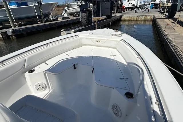 Slide: The Image of 2012 Sea Hunt Triton 225 boat docked at marina, showcasing spacious deck layout. - 13