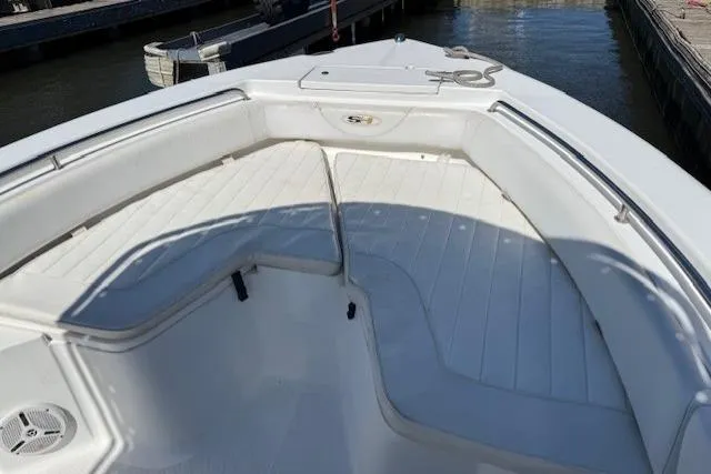 Slide: The Image of 2012 Sea Hunt Triton 225 boat with white seating and docked at marina. - 14