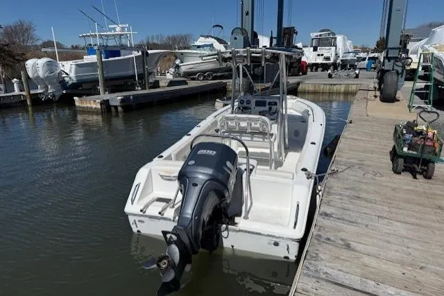 Slide: The Image of 2012 Sea Hunt Triton 225 boat docked at marina with outboard motor. - 2