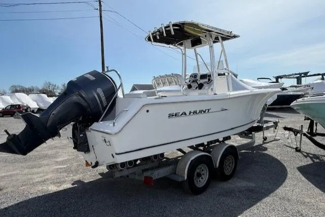 Slide: The Image of 2012 Sea Hunt Triton 225 boat on trailer, featuring outboard motor and T-top. - 4