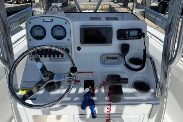 Slide: The Image of Console of 2012 Sea Hunt Triton 225 boat with steering wheel and navigation equipment. - 6