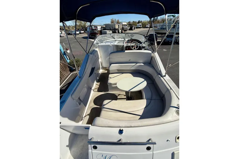 Slide: The Image of 2000 Four Winns 288 Vista boat interior with seating and table, docked outdoors. - 3