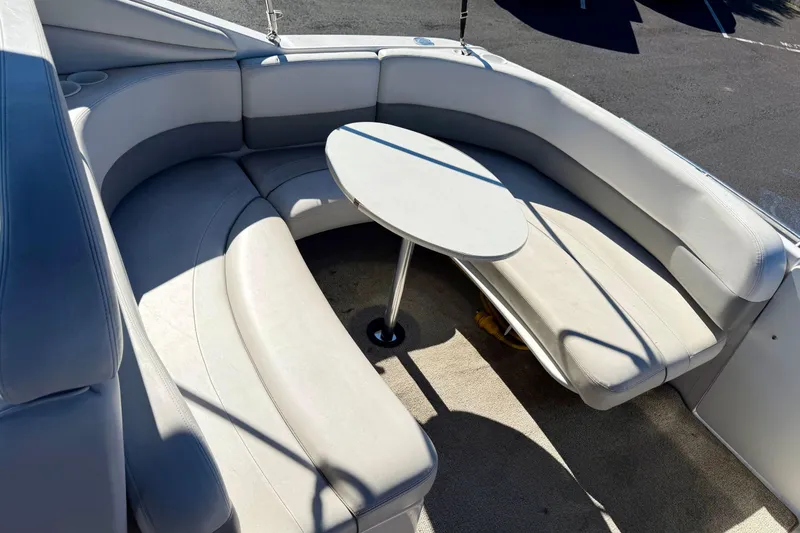 Slide: The Image of 2000 Four Winns 288 Vista boat interior with curved seating and table. - 4