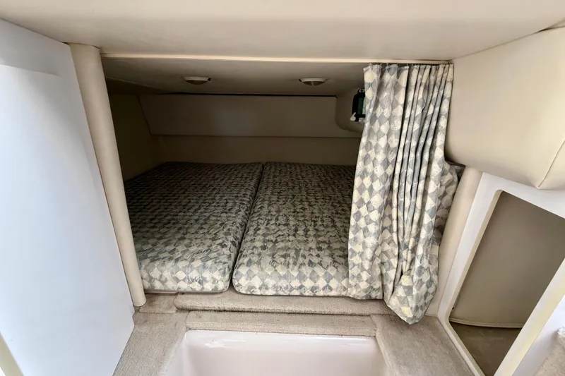Slide: The Image of 2000 Four Winns 288 Vista cabin interior with patterned bedding and privacy curtain. - 7