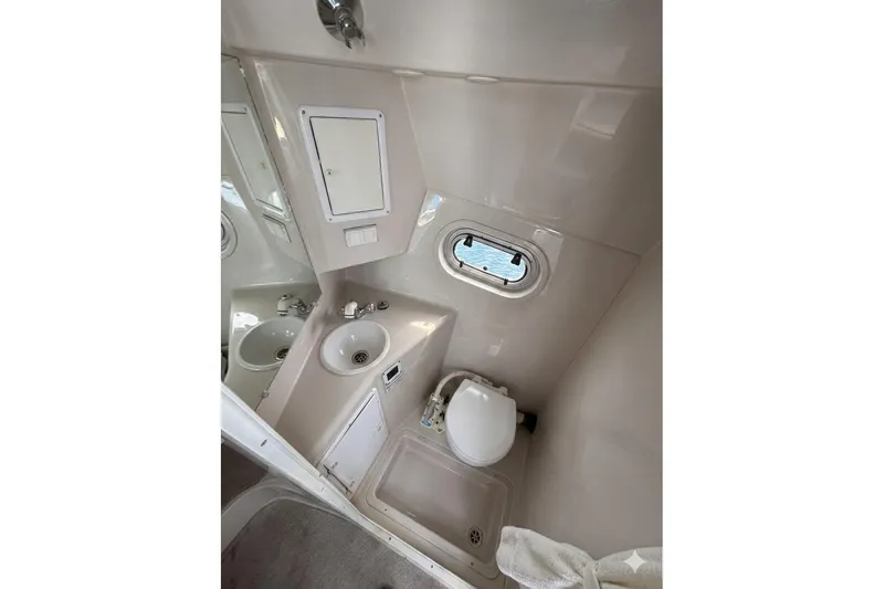 Slide: The Image of Bathroom interior of 2000 Four Winns 288 Vista boat, featuring sink and toilet. - 8