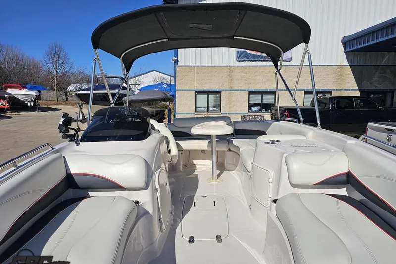 Slide: The Image of 2015 Tahoe 215 Xi boat interior with seating and canopy in a marina setting. - 100