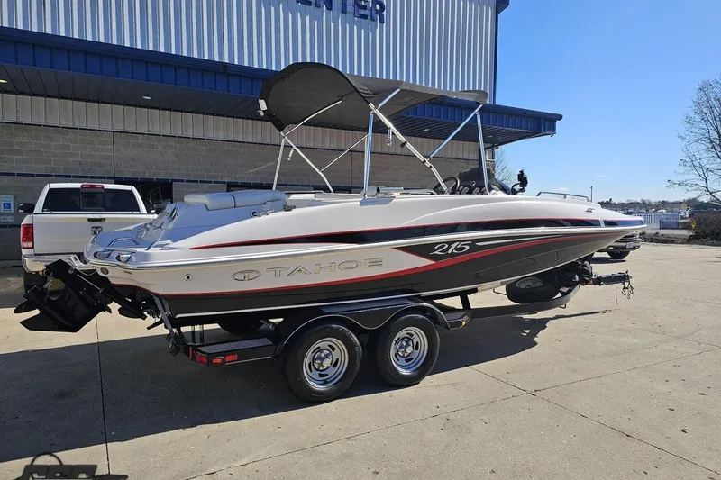 Slide: The Image of 2015 Tahoe 215 Xi boat on trailer outside a building. - 11