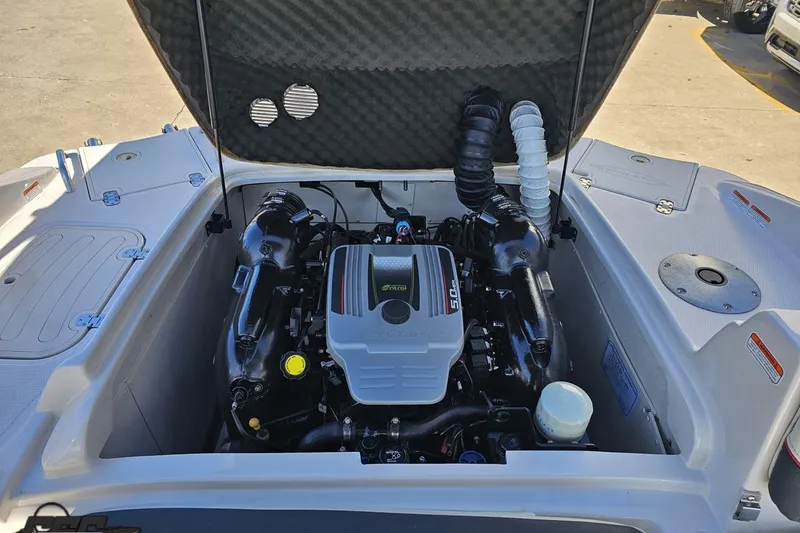 Slide: The Image of 2015 Tahoe 215 Xi boat engine compartment with open hatch, showcasing the engine details. - 113