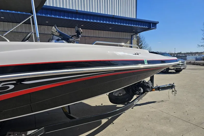 Slide: The Image of 2015 Tahoe 215 Xi boat on trailer, parked outside industrial building. - 14