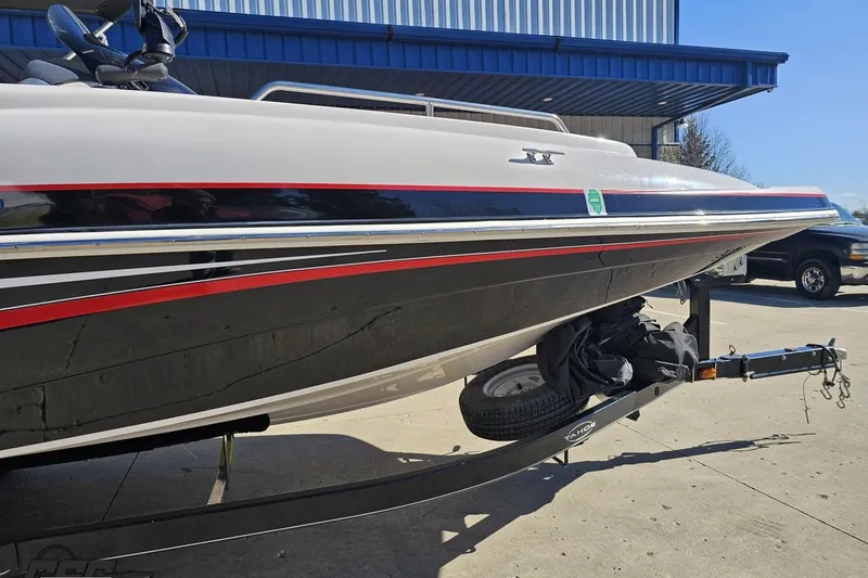 Slide: The Image of 2015 Tahoe 215 Xi boat on trailer, featuring sleek black and red accents. - 15