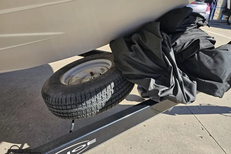Slide: The Image of 2015 Tahoe 215 Xi boat on trailer with tire and cover visible. - 18