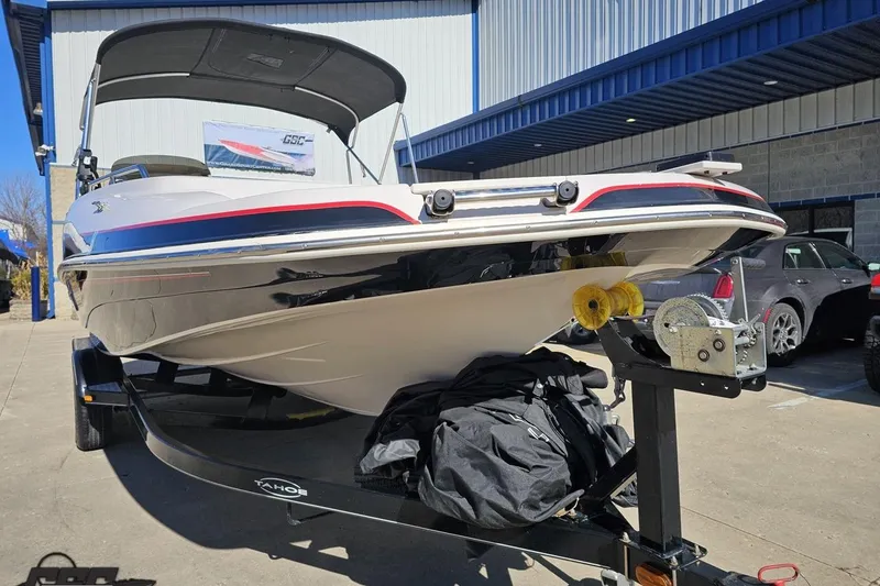 Slide: The Image of 2015 Tahoe 215 Xi boat on trailer outside a building. - 20