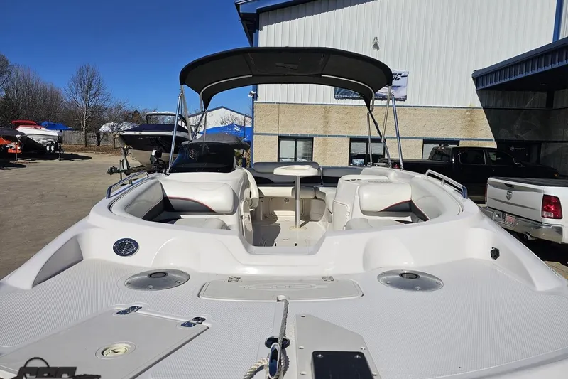 Slide: The Image of 2015 Tahoe 215 Xi boat with seating and canopy in a marina setting. - 23