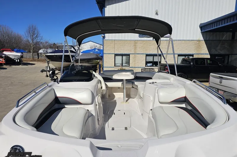 Slide: The Image of 2015 Tahoe 215 Xi boat with spacious seating and canopy in a marina setting. - 24