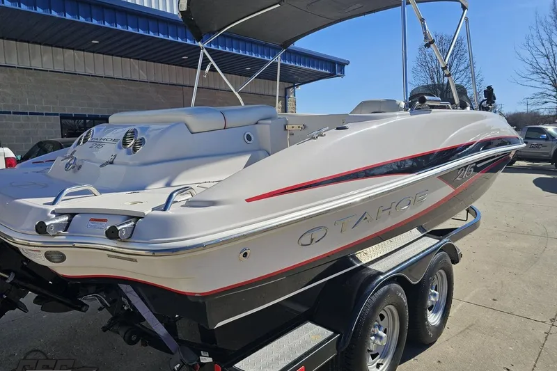 Slide: The Image of 2015 Tahoe 215 Xi boat on trailer, parked outdoors under clear sky. - 40