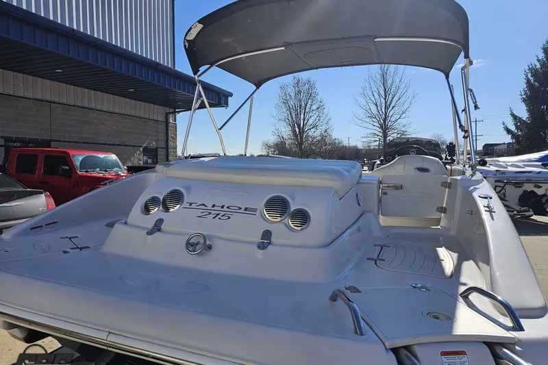 Slide: The Image of 2015 Tahoe 215 Xi boat with canopy, parked outdoors under clear sky. - 42