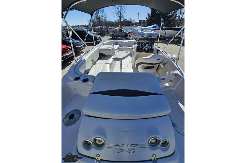 Slide: The Image of 2015 Tahoe 215 Xi boat interior with seating and steering wheel, docked outdoors. - 44