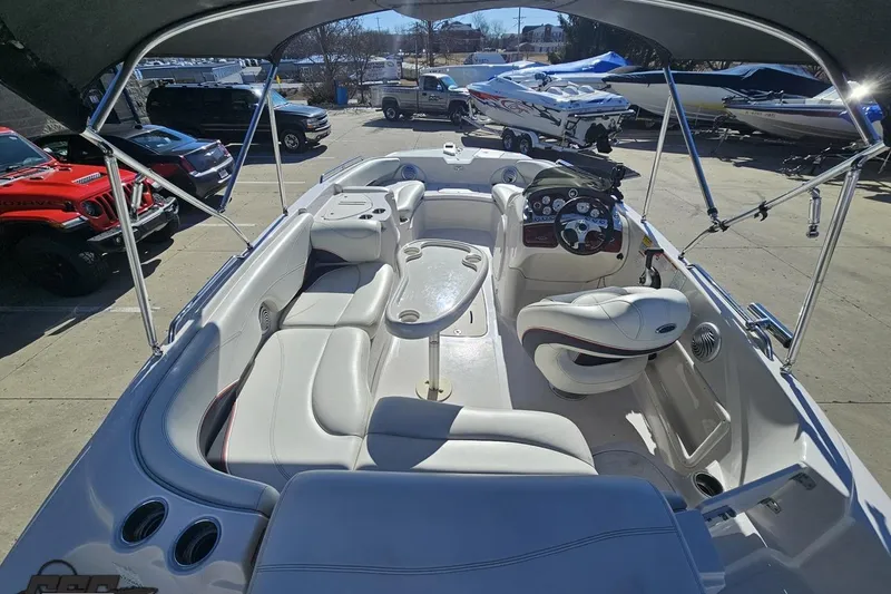 Slide: The Image of 2015 Tahoe 215 Xi boat interior with seating and steering wheel, parked outdoors. - 46
