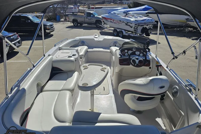 Slide: The Image of 2015 Tahoe 215 Xi boat interior with seating and steering wheel in a parking lot. - 50