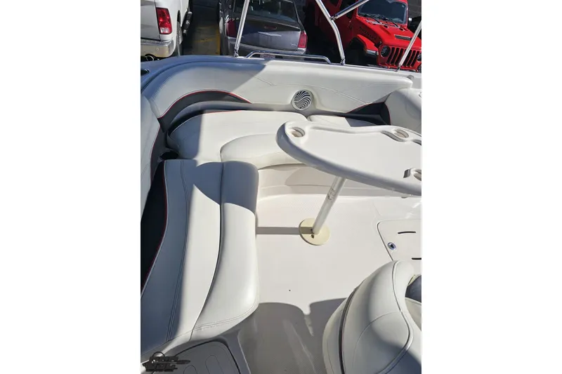 Slide: The Image of 2015 Tahoe 215 Xi boat interior with white seating and table, showcasing spacious design. - 53